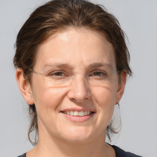 Joyful white adult female with medium  brown hair and grey eyes