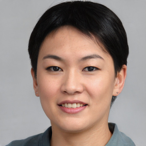 Joyful asian young-adult female with short  black hair and brown eyes
