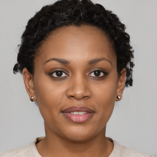 Joyful black young-adult female with short  brown hair and brown eyes