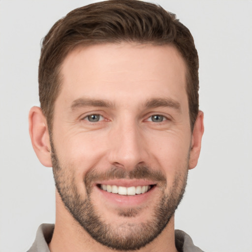 Joyful white young-adult male with short  brown hair and brown eyes