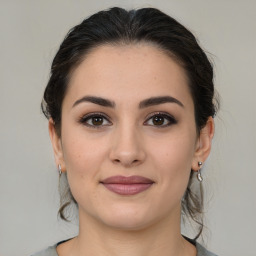 Joyful white young-adult female with medium  brown hair and brown eyes