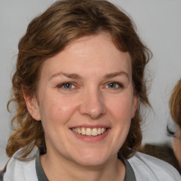 Joyful white adult female with medium  brown hair and blue eyes