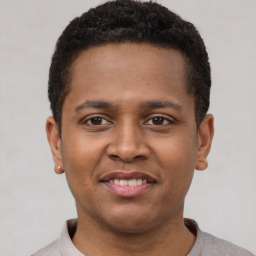 Joyful latino young-adult male with short  brown hair and brown eyes