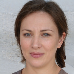 Joyful white adult female with medium  brown hair and grey eyes