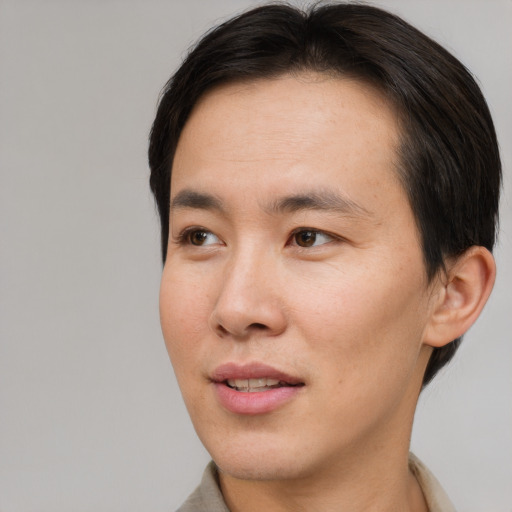 Joyful asian young-adult male with short  brown hair and brown eyes
