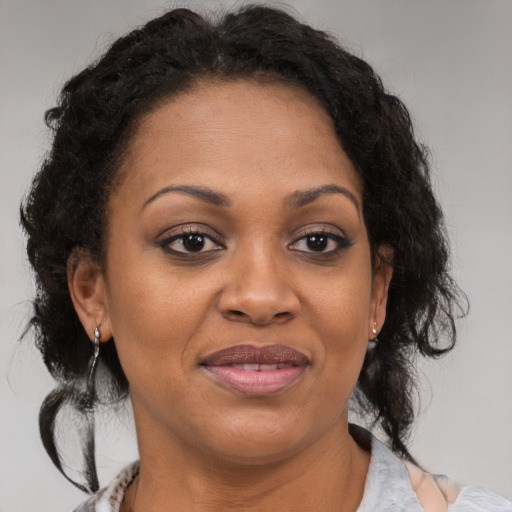 Joyful black adult female with medium  brown hair and brown eyes