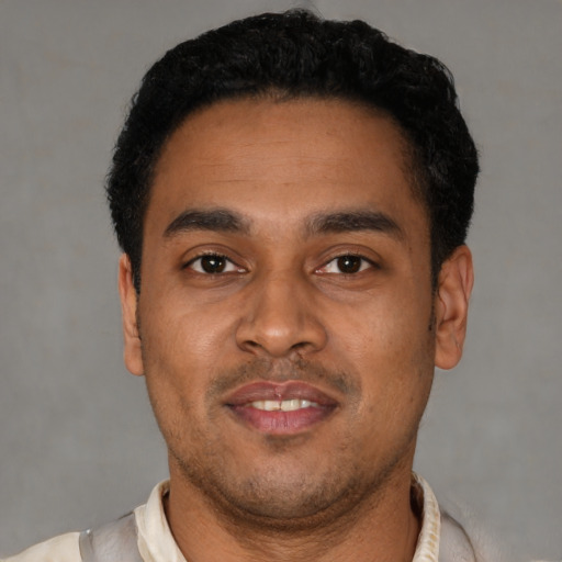 Joyful latino young-adult male with short  black hair and brown eyes