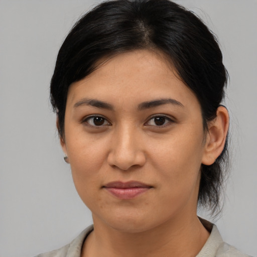 Joyful latino young-adult female with medium  brown hair and brown eyes