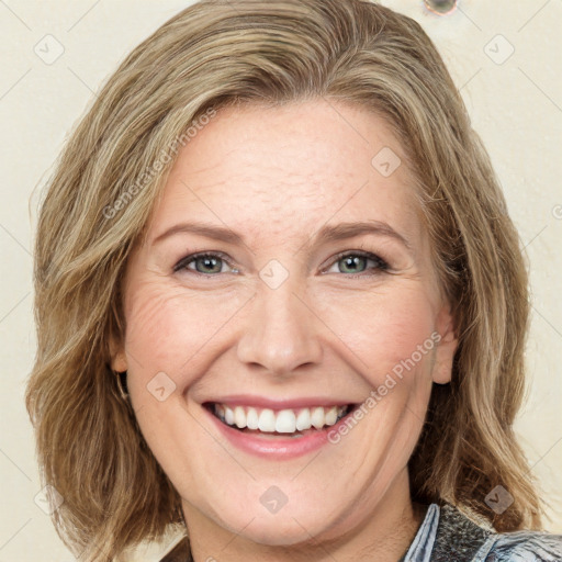 Joyful white young-adult female with medium  brown hair and green eyes