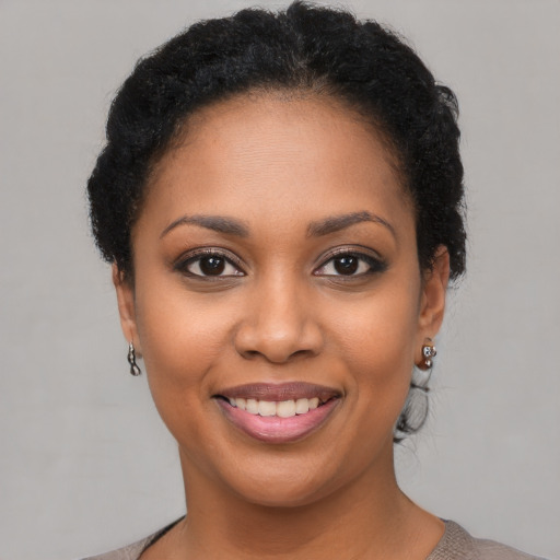 Joyful black young-adult female with short  brown hair and brown eyes