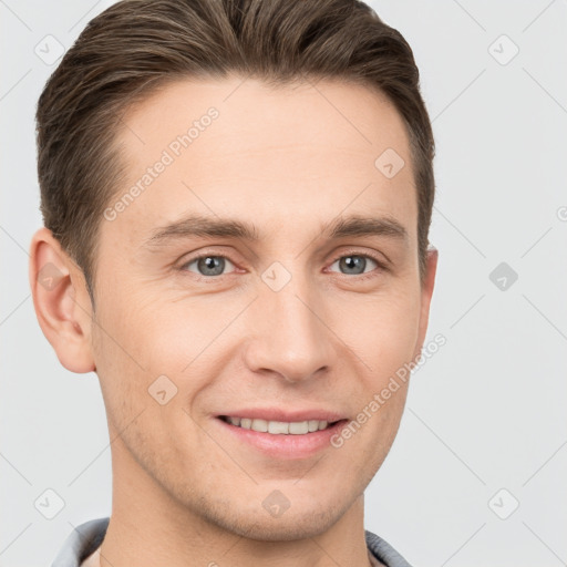 Joyful white young-adult male with short  brown hair and grey eyes