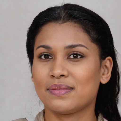 Joyful black young-adult female with long  brown hair and brown eyes