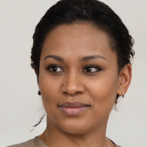 Joyful black young-adult female with short  brown hair and brown eyes