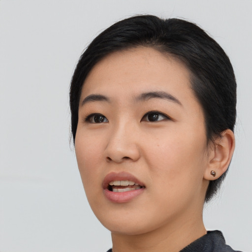 Joyful asian young-adult female with medium  black hair and brown eyes