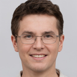 Joyful white adult male with short  brown hair and grey eyes