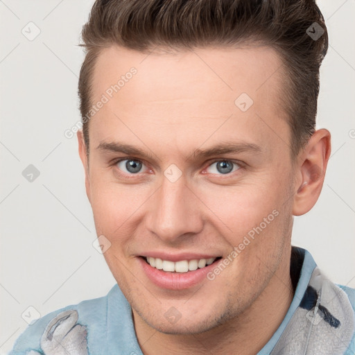 Joyful white young-adult male with short  brown hair and grey eyes