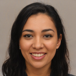 Joyful latino young-adult female with long  brown hair and brown eyes