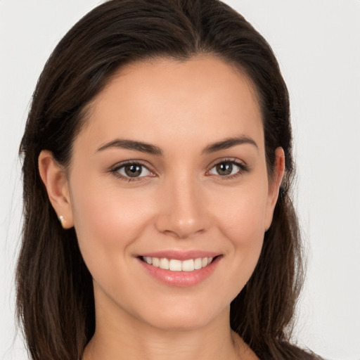 Joyful white young-adult female with long  brown hair and brown eyes