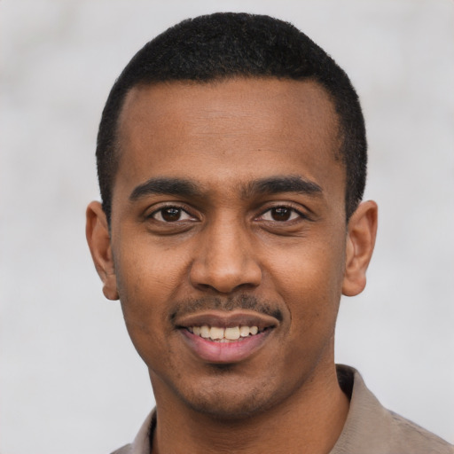 Joyful black young-adult male with short  black hair and brown eyes