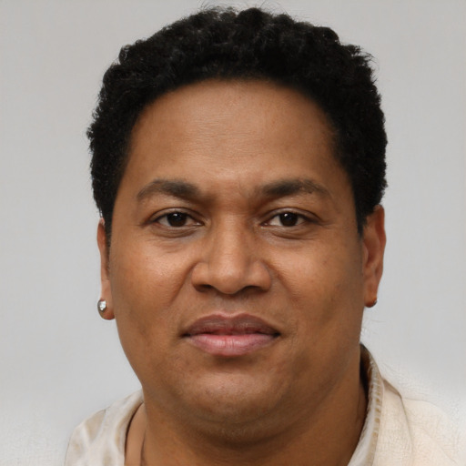 Joyful black adult male with short  brown hair and brown eyes