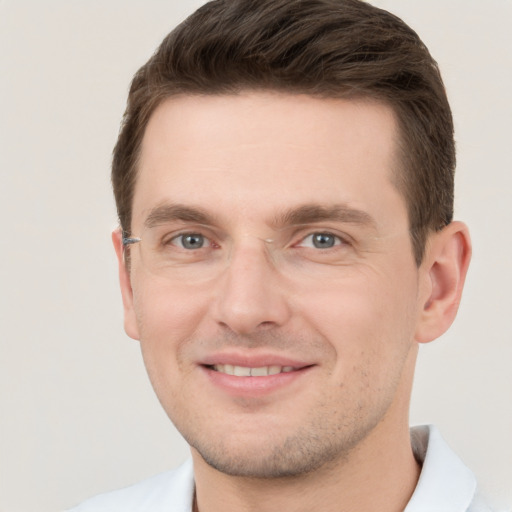 Joyful white young-adult male with short  brown hair and grey eyes