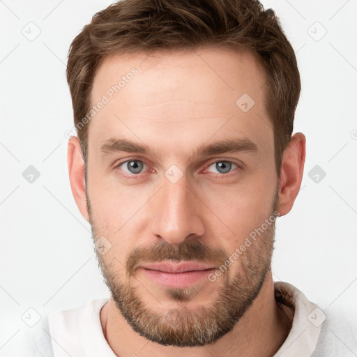 Joyful white young-adult male with short  brown hair and grey eyes