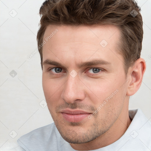 Joyful white young-adult male with short  brown hair and grey eyes