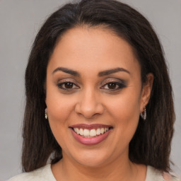 Joyful latino young-adult female with medium  brown hair and brown eyes