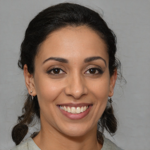 Joyful latino young-adult female with medium  brown hair and brown eyes