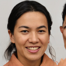 Joyful asian young-adult female with medium  brown hair and brown eyes