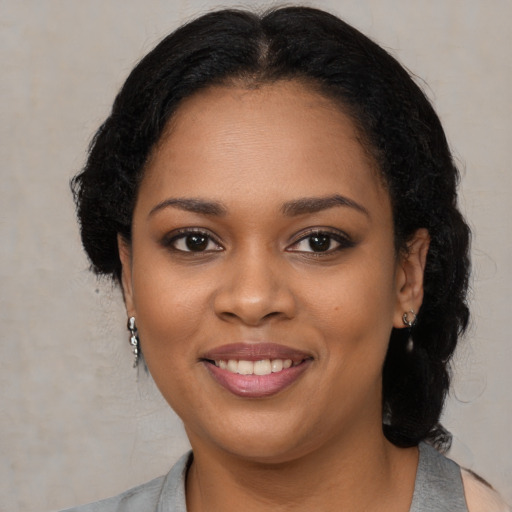 Joyful black young-adult female with medium  black hair and brown eyes