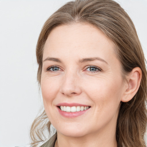 Joyful white young-adult female with long  brown hair and blue eyes