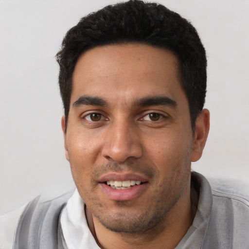 Joyful white young-adult male with short  black hair and brown eyes