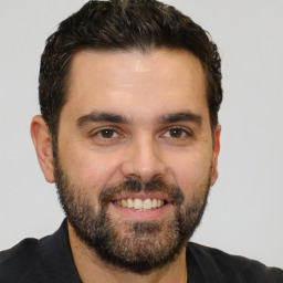 Joyful white young-adult male with short  black hair and brown eyes