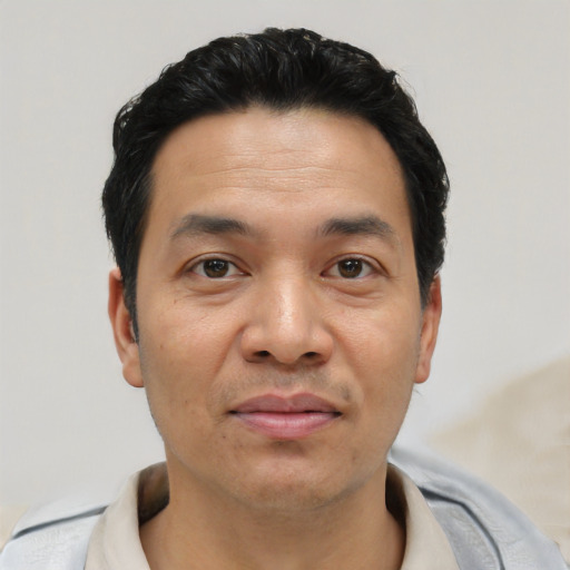 Joyful asian young-adult male with short  black hair and brown eyes