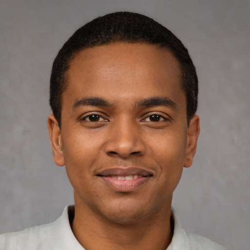 Joyful black young-adult male with short  brown hair and brown eyes