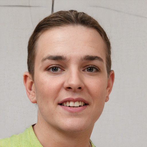 Joyful white young-adult female with short  brown hair and grey eyes