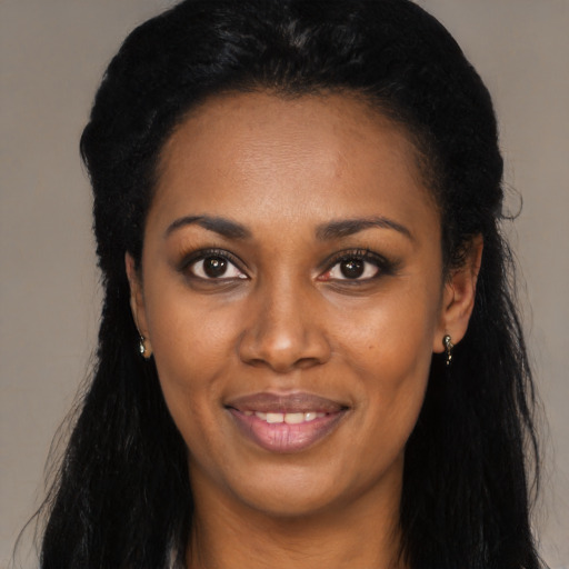 Joyful black young-adult female with long  black hair and brown eyes