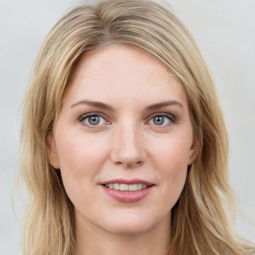 Joyful white young-adult female with long  brown hair and blue eyes