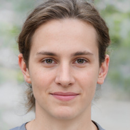 Joyful white young-adult female with medium  brown hair and grey eyes