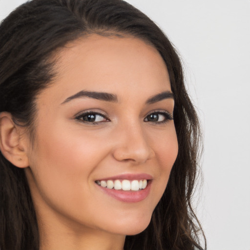 Joyful white young-adult female with long  brown hair and brown eyes