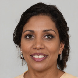 Joyful black adult female with medium  brown hair and brown eyes