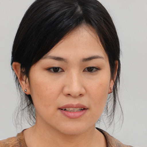 Joyful asian young-adult female with medium  brown hair and brown eyes