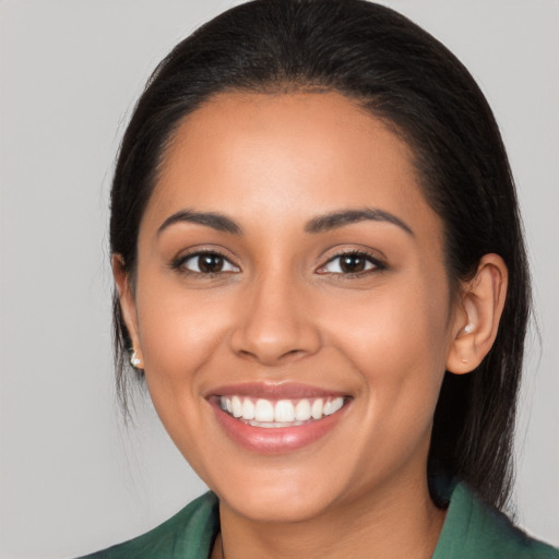 Joyful latino young-adult female with long  brown hair and brown eyes