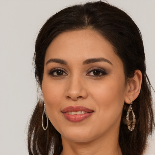 Joyful latino young-adult female with long  brown hair and brown eyes