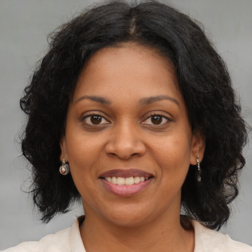 Joyful black young-adult female with medium  brown hair and brown eyes