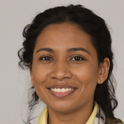 Joyful black adult female with medium  brown hair and brown eyes