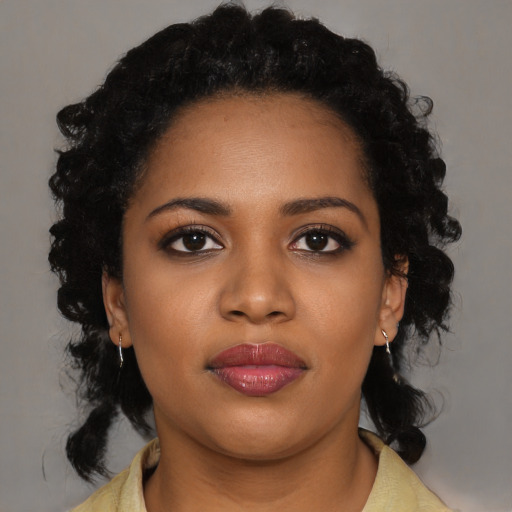 Joyful black young-adult female with medium  black hair and brown eyes