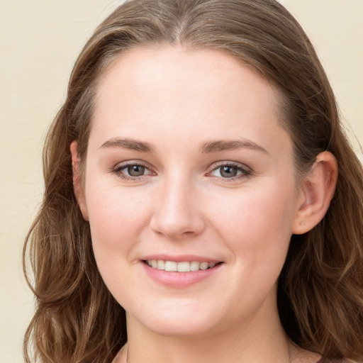 Joyful white young-adult female with long  brown hair and grey eyes