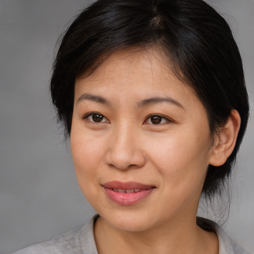 Joyful asian adult female with medium  brown hair and brown eyes